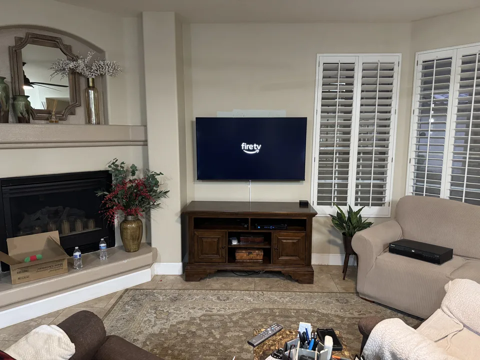 New 55-inch Hisense Fire TV mounted on a full-motion wall mount above the console