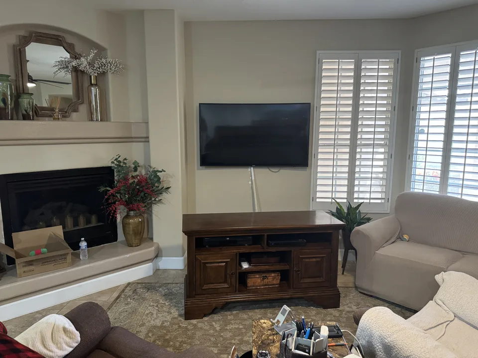 Previous 55-inch television mounted above a wooden console before the upgrade