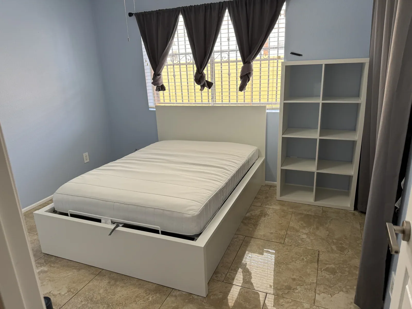 Finished white storage bed and matching bookshelf assembled in a Phoenix bedroom
