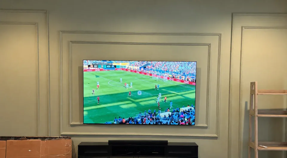 Finished 77-inch LG OLED TV mounted level on a decorative Phoenix living-room wall